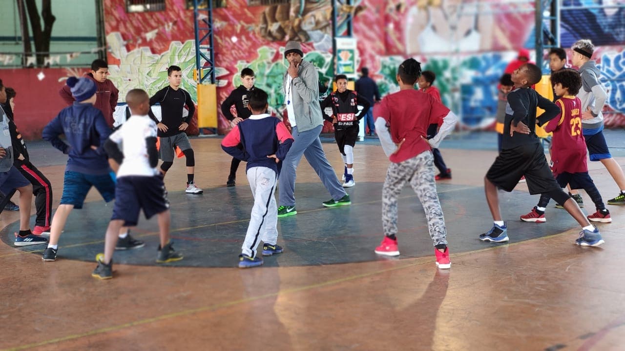 Crianças e adolescentes em treino coletivo de basquete
