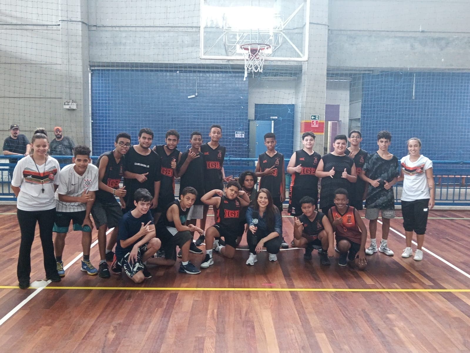 Atletas do Instituto Gomes Basquete reunidos com a repórter do SBT após a reportagem